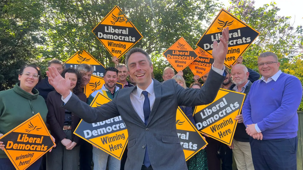 Mike in front of a crowd holding Lib Dem signs